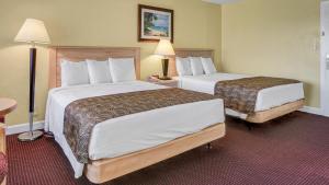 a hotel room with two beds and two lamps at Page Terrace Beachfront Hotel in St. Pete Beach