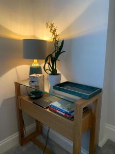 a table with a lamp and books on it at Hideaway Holiday Apartment in Salisbury