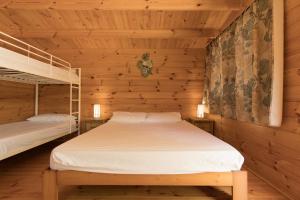 Venta del MoroにあるSlow Life Camping Venta del Moroの木造キャビン内のベッドルーム1室(二段ベッド2組付)