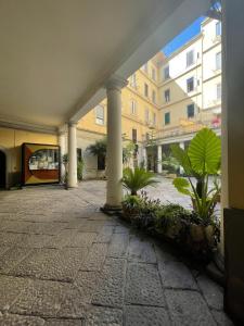 pusty dziedziniec w budynku z kolumnami i roślinami w obiekcie Dimora Centrale Home w mieście Napoli