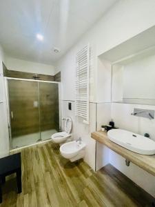 łazienka z 2 toaletami, umywalką i prysznicem w obiekcie Dimora Centrale Home w mieście Napoli
