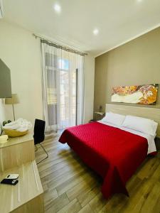 sypialnia z dużym czerwonym łóżkiem i biurkiem w obiekcie Dimora Centrale Home w mieście Napoli