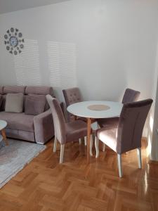 ein Wohnzimmer mit einem Tisch, Stühlen und einem Sofa in der Unterkunft Sunrise Apartments sa garažom in Banja Luka