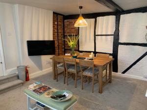 een woonkamer met een houten tafel en stoelen bij Hideaway Holiday Apartment in Salisbury