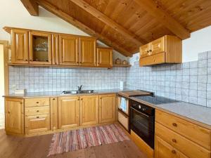 eine Küche mit Holzschränken, einer Spüle und einem Herd in der Unterkunft Dolomiten View - South Tyrol in Villanders