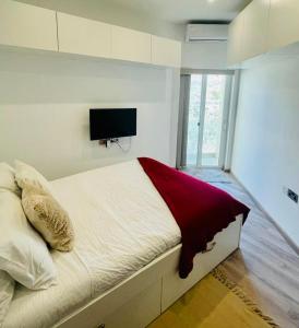 um quarto com uma cama e uma televisão na parede em Beach front High End apartment, direct sea views. em Marsalforn