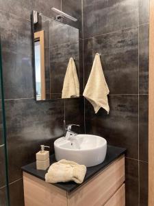 uma casa de banho com um lavatório e um espelho em Beach front High End apartment, direct sea views. em Marsalforn