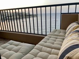 uma varanda com vista para o mar e um sofá em Beach front High End apartment, direct sea views. em Marsalforn