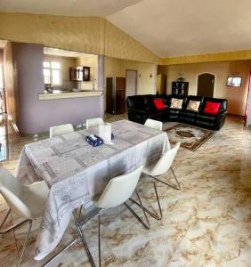 a living room with a table and white chairs at Baie du Tombeau Apartment in Baie du Tombeau