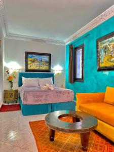 a bedroom with a bed and a couch and a table at Riad Baddi in Salé