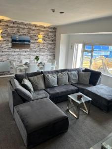 a living room with a couch and a table at Sea View Lavish Apartment SKY TV Whirlpool Bath HUGE Balcony NEWLY REFURBISHED in Bridlington