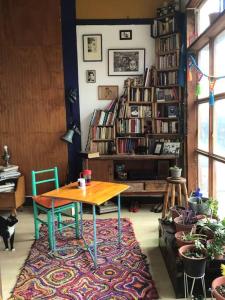 uma mesa e cadeiras num quarto com uma estante de livros em Gran Departamento en Cerro Alegre con única vista al puerto em Valparaíso