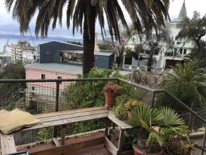 un banco de madera sentado en un balcón con plantas en Gran Departamento en Cerro Alegre con única vista al puerto, en Valparaíso