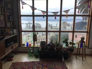 una habitación con una gran ventana con un montón de macetas en Gran Departamento en Cerro Alegre con única vista al puerto en Valparaíso