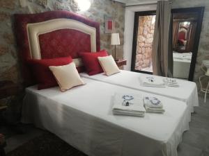 1 dormitorio con 1 cama blanca grande con almohadas rojas en 3 Marias - Nº20 - T1 en Lousa