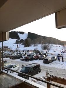 ein Parkplatz mit Autos im Schnee in der Unterkunft Metabief- Front de piste in Métabief