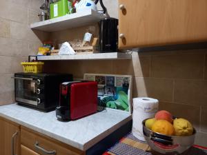 a kitchen counter with a red toaster and a bowl of fruit at Pozzuoli 100per100 Home in Pozzuoli