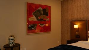 a room with a bed and a painting on the wall at Ambiance Boutique Art Hotel Karachi in Karachi