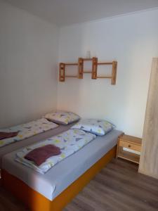 ein Schlafzimmer mit 2 Betten und einem Regal an der Wand in der Unterkunft Flower Bike in Štúrovo