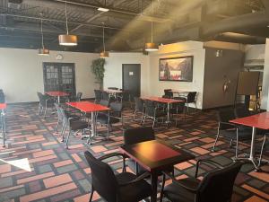 une chambre avec des tables et des chaises dans un bâtiment dans l'établissement Super 8 by Wyndham Macleod Trail Calgary, à Calgary