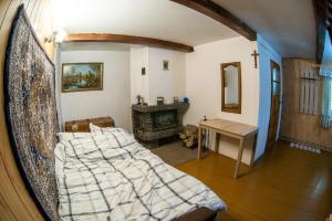 a bedroom with a bed and a table and a fireplace at Agroturystyka u Wojtka 