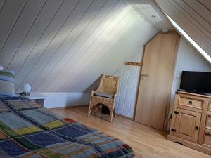 um quarto com uma cama e uma televisão num sótão em Wohnung zum Wohlfühlen em Netphen