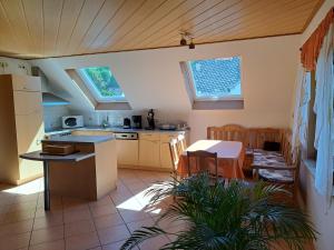 kuchnia i jadalnia ze stołem i krzesłami w obiekcie Wohnung zum Wohlfühlen w mieście Netphen