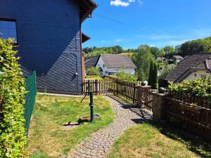 a yard with a wooden fence and a gate at Wohnung zum Wohlfühlen in Netphen