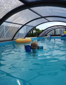 - une petite fille nageant dans une piscine dans l'établissement FeWo Obstbäumle mit Pool Matzenweilerhof, à Neukirch