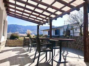 a patio with a table and chairs under a wooden pergola at Puro Campo in Tafí del Valle