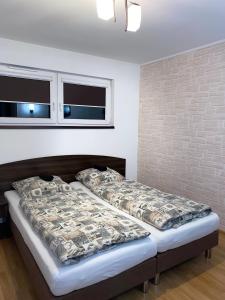 een slaapkamer met 2 bedden en een bakstenen muur bij Zajazd Kadar in Wisła