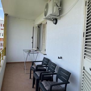 uma fila de cadeiras numa varanda com uma janela em Swallow Nest em Durrës