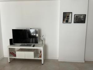 einen TV auf einem weißen Stand in einem Zimmer in der Unterkunft Temponorte Salta II in Salta