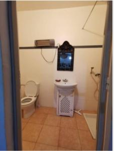 TV y baño con aseo y lavamanos. en Riad taddert, en Marrakech