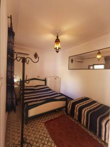 1 dormitorio con 2 camas y espejo en Riad taddert, en Marrakech