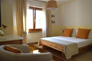 sypialnia z łóżkiem, kanapą i oknem w obiekcie CividaleMia, casa vacanza w mieście Cividale del Friuli