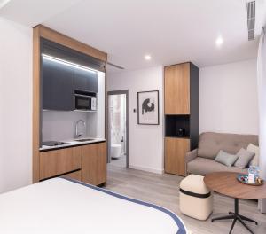 a bedroom with a bed and a couch and a table at Jerusalén Suites Alicante in Alicante +17 photos