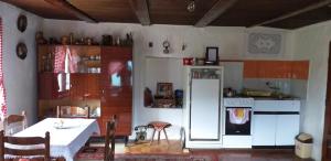 a kitchen with a table and a white refrigerator at Etno guest house Lalovic in Tjentište