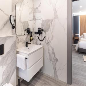 W łazience znajduje się biała umywalka i lustro. w obiekcie Jerusalén Suites Alicante w Alicante