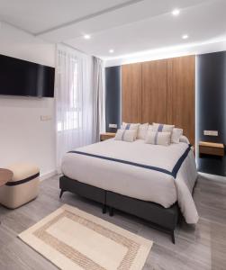 1 dormitorio con 1 cama grande y TV en Jerusalén Suites Alicante, en Alicante