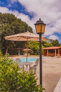 a table and an umbrella next to a pool at Villaflor Pousada in Vale do Capao