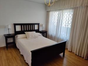 a bedroom with a large bed and a window at Ático Carrasco in Benidorm