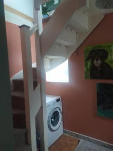 a washing machine in a bathroom with a staircase at Cosy Wellbeing Stays on Cornish Coast in Falmouth