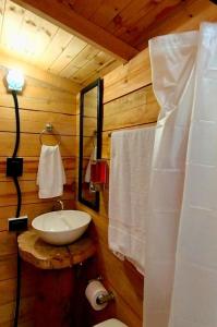 un bagno con lavandino in una baita di tronchi di Glamping El Edén Guasca Cundinamarca a Guasca