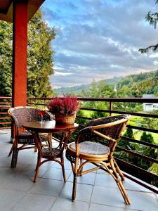 a table and chairs on a balcony with a view of a valley at Zajazd Kadar in Wisła