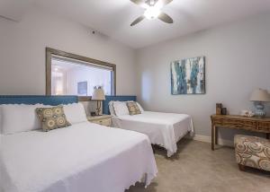 a bedroom with two beds and a ceiling fan at My Sapphire South Padre in South Padre Island