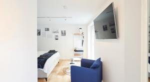 ein Wohnzimmer mit einem blauen Stuhl und einem Bett in der Unterkunft Wohnträumerei Petit - Stilvoll eingerichtetes und ruhiges Design Apartment in Göttingen