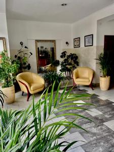 - un salon avec deux chaises et des plantes dans l'établissement Zajazd Kadar, à Wisła