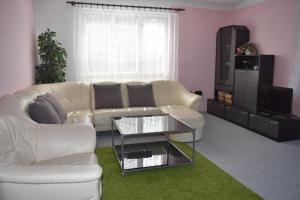 a living room with a white couch and a tv at Penzion243 in Tábor
