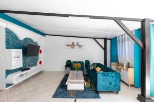 a living room with a blue couch and a table at Villa Comfort-Soleil in Kourou